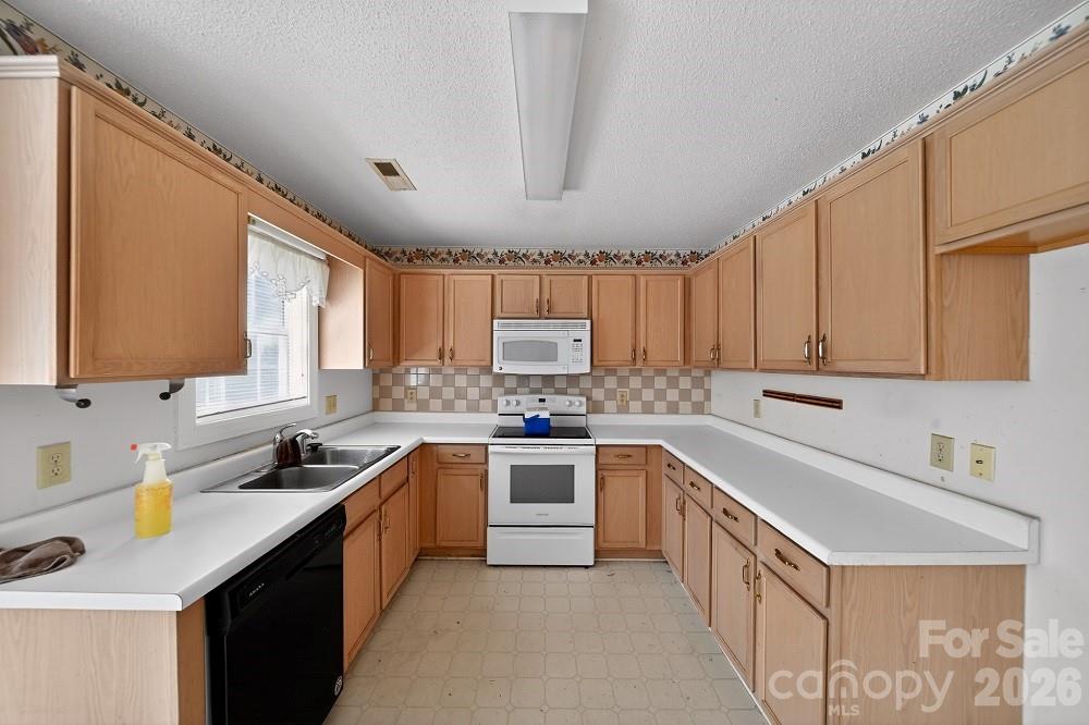 2205 Old Sparta Road Rocky Mount, NC 27804 - Photo 7 of 25 a kitchen with a sink stove top oven and cabinets