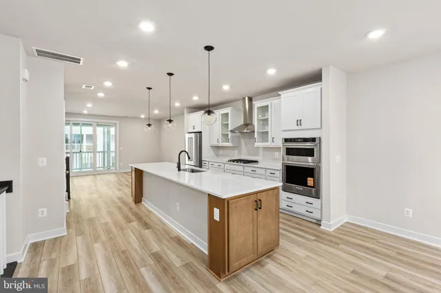 a large kitchen with kitchen island a sink stainless steel appliances and cabinets
