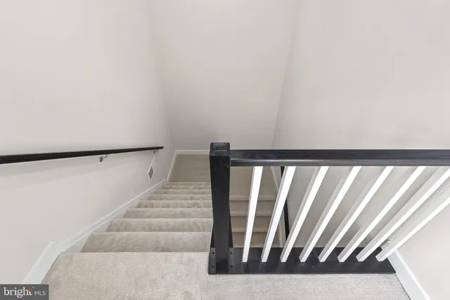 a view of staircase with white walls and a window