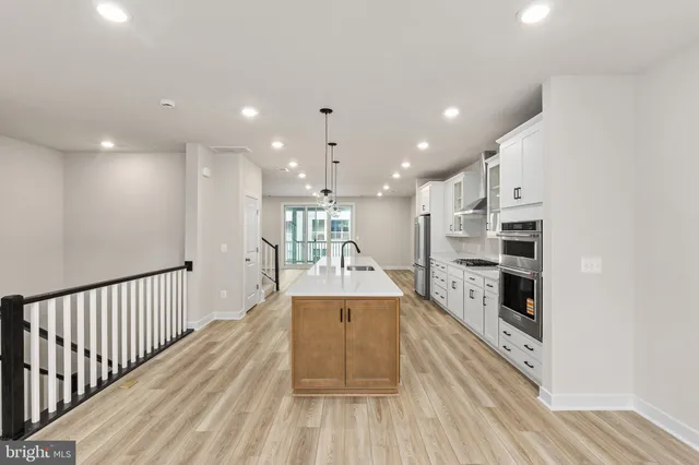a open kitchen with kitchen island a stove and a wooden floors