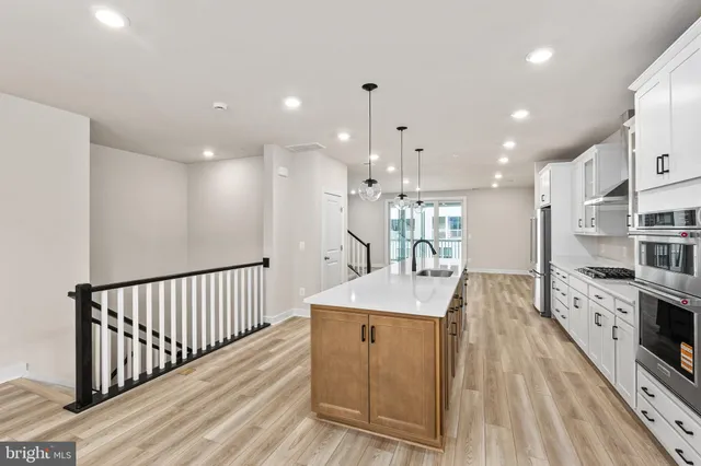 a kitchen with stainless steel appliances kitchen island granite countertop a sink and cabinets