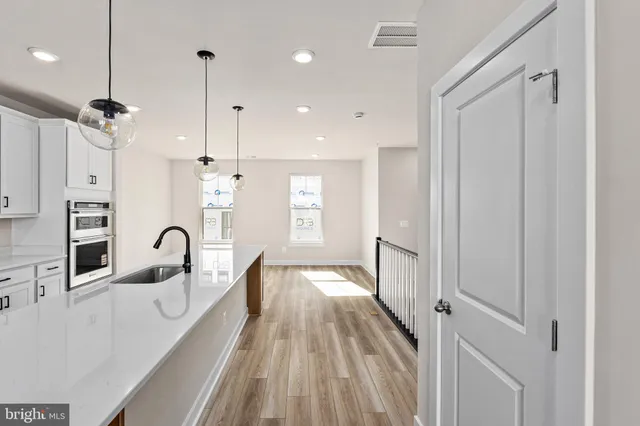 a view of a kitchen counter space a sink and wooden floor