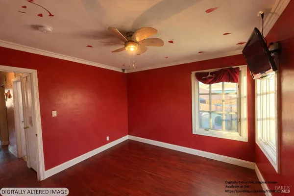 a view of an empty room with window and wooden floor