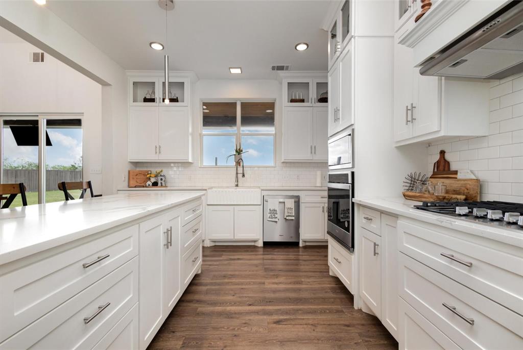 601 Gin Road Ennis, TX 75119 - Photo 11 of 33 a kitchen with stainless steel appliances sink a stove and cabinets