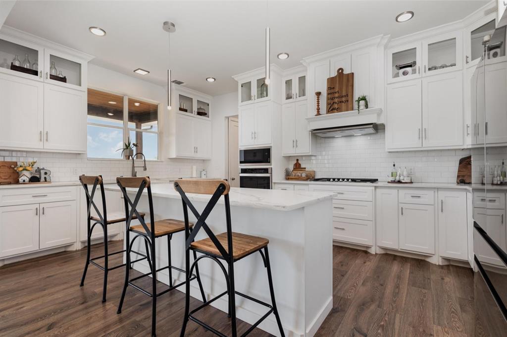 601 Gin Road Ennis, TX 75119 - Photo 9 of 33 a kitchen with stainless steel appliances a stove a table and chairs in it