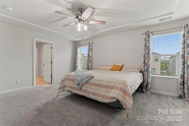 a spacious bedroom with a bed and a chandelier