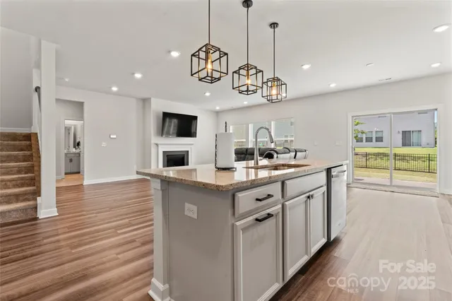 a kitchen with stainless steel appliances granite countertop a sink and dishwasher a stove top oven with wooden floor