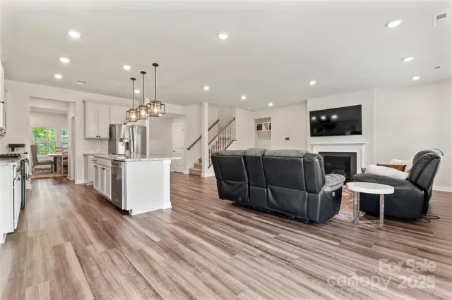 a living room with furniture a flat screen tv and kitchen view