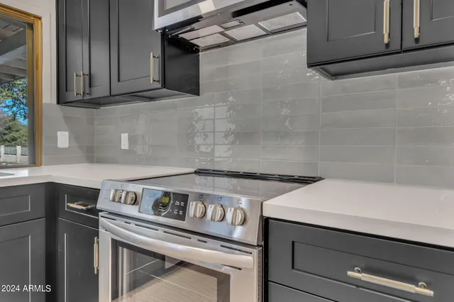 a view of a stove with wooden cabinets