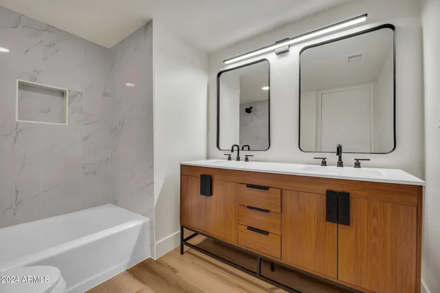 a bathroom with a tub sink and mirror