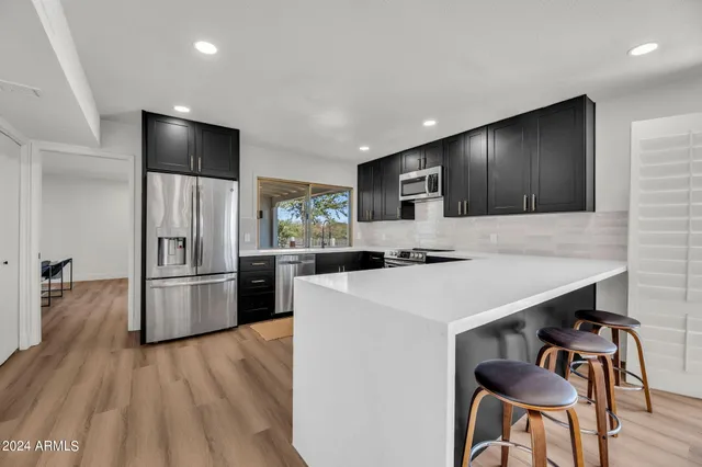 a kitchen with refrigerator cabinets and wooden floor