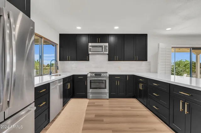 a kitchen with stainless steel appliances granite countertop a refrigerator and a stove top oven