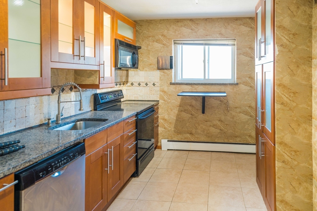 20 Westgate Road, Unit 6 Boston, MA 02467 - Photo 6 of 25 a kitchen with granite countertop a sink stove and cabinets