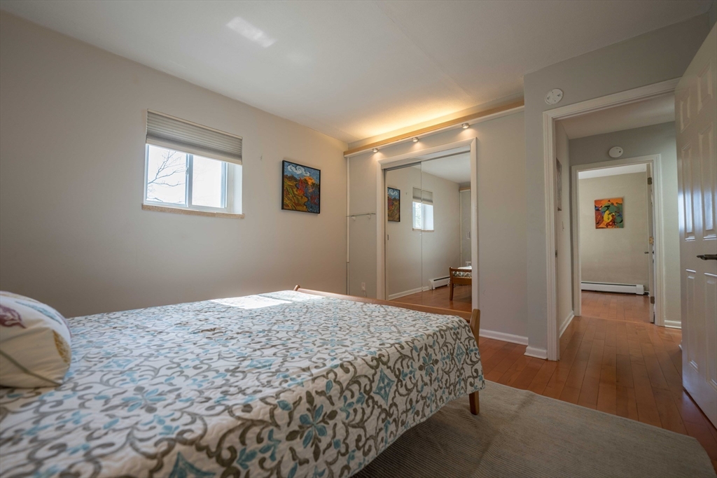 20 Westgate Road, Unit 6 Boston, MA 02467 - Photo 9 of 25 a bedroom with a bed and wooden floor