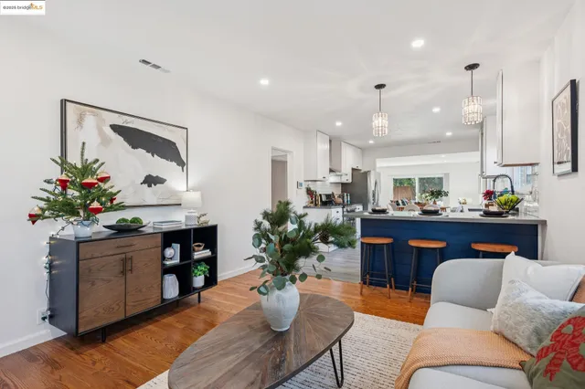 a living room with furniture kitchen view and a potted plant