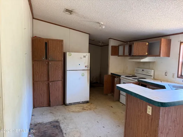 a kitchen that has a refrigerator and a stove in it