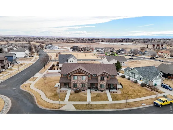 an aerial view of a house with a yard and ocean view