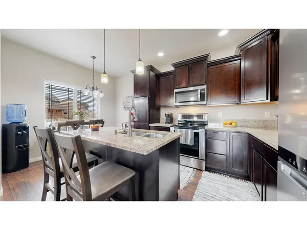 a kitchen with kitchen island stainless steel appliances a sink and cabinets