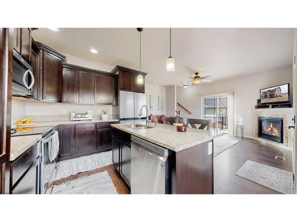 a kitchen with kitchen island granite countertop a sink counter top space and stainless steel appliances