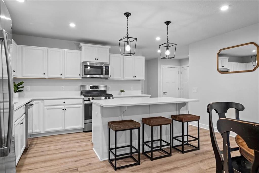 718 Celia Way Harmony, PA 16037 - Photo 6 of 23 a kitchen with stainless steel appliances granite countertop a stove a sink dishwasher a dining table and chair with wooden floor
