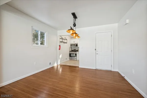 a view of empty room with wooden floor