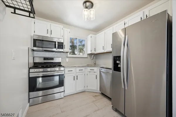 a kitchen with stainless steel appliances a refrigerator sink and microwave