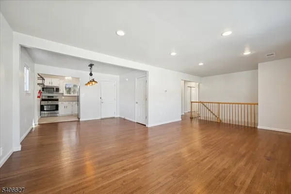 a view of empty room with wooden floor