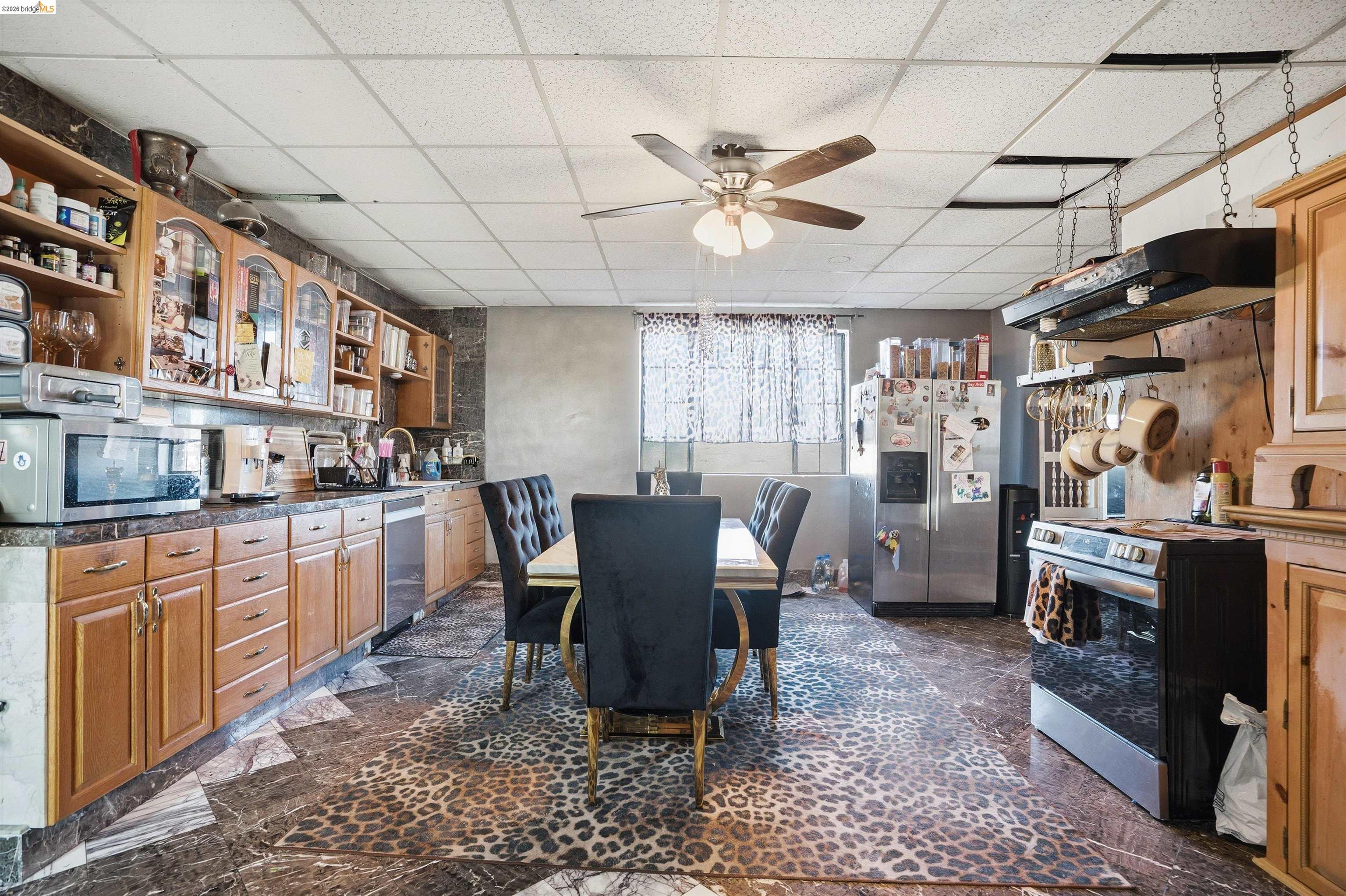511 Third Street Rodeo, CA 94572 - Photo 4 of 25 a kitchen with stainless steel appliances granite countertop a sink dishwasher a stove a dining table and chairs with wooden floor