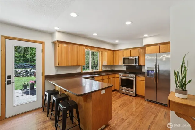 a kitchen with stainless steel appliances granite countertop refrigerator sink and cabinets