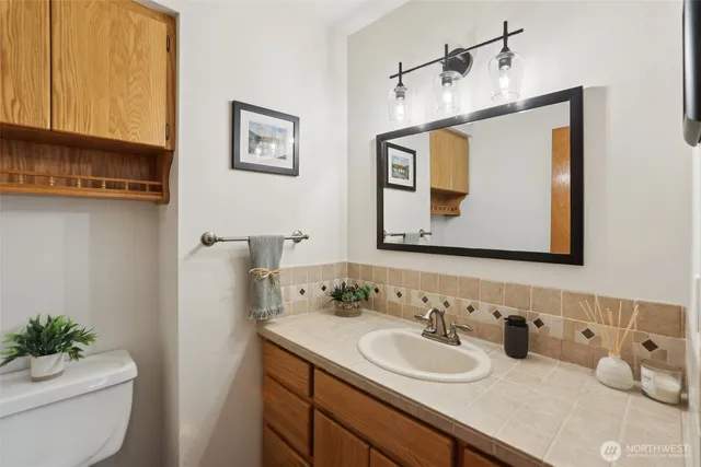 a bathroom with a toilet sink and mirror