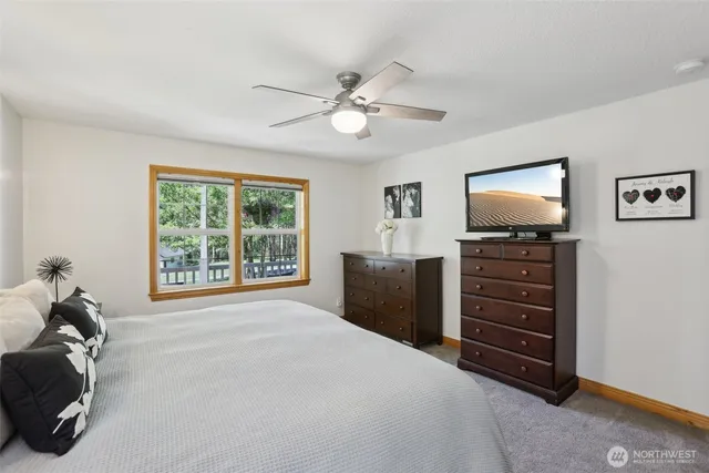 a bedroom with a bed and a flat tv screen on dresser
