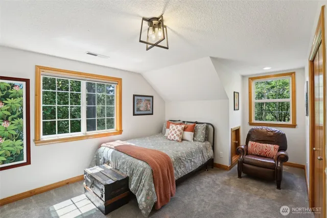 a bedroom with bed couch and window