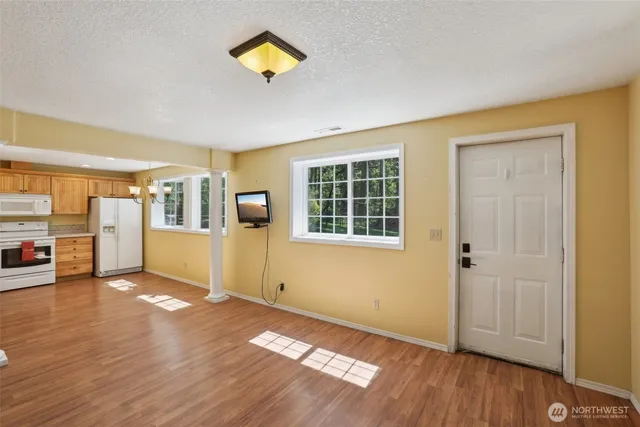 a kitchen with a white cabinets a sink stainless steel appliances and wooden floor