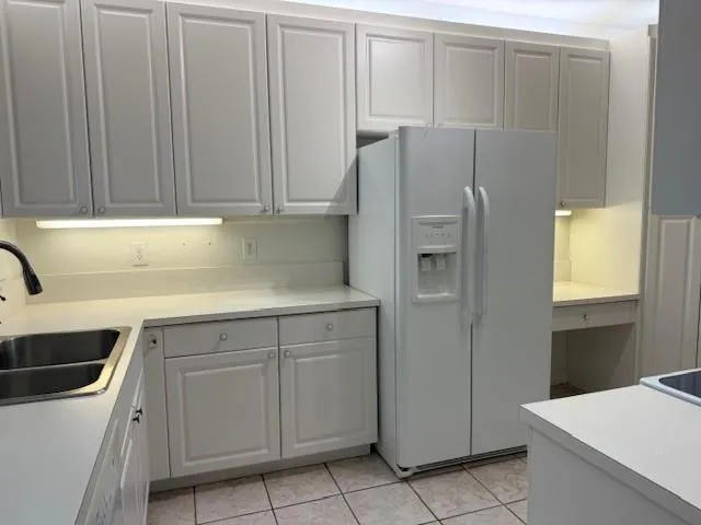 a kitchen with white cabinets and white appliances