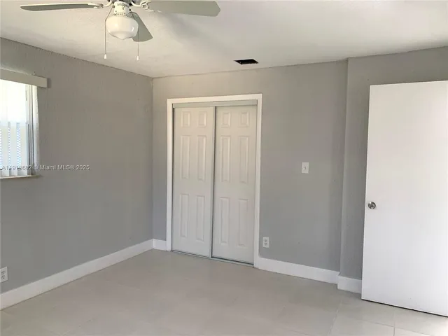 an empty room with a chandelier fan