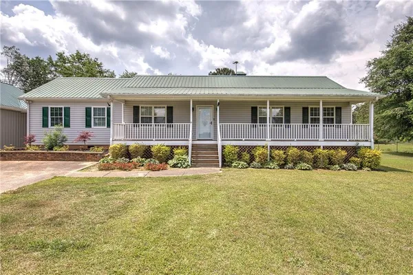 a front view of a house with a big yard and potted plants