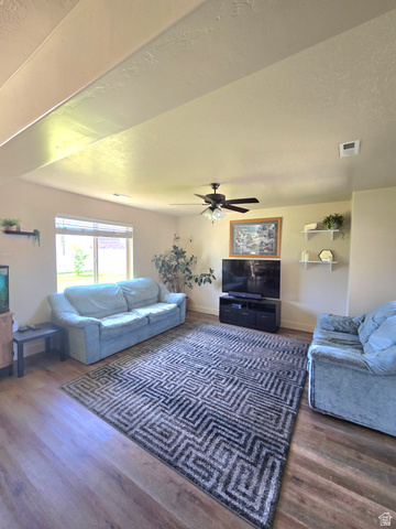 601 West 150 North, Unit 25 Springville, UT 84663 - Photo 3 of 29 Spacious room featuring wood-finish flooring, a contemporary ceiling fan, and ample natural light from a prominent window