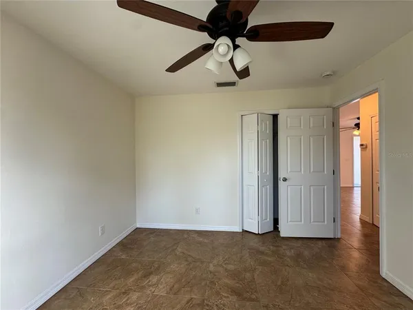 en empty room with ceiling fan and window