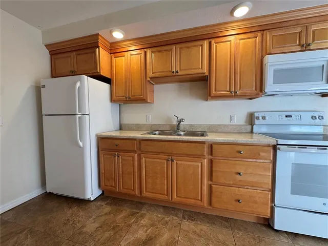 a kitchen with cabinets a refrigerator and a sink