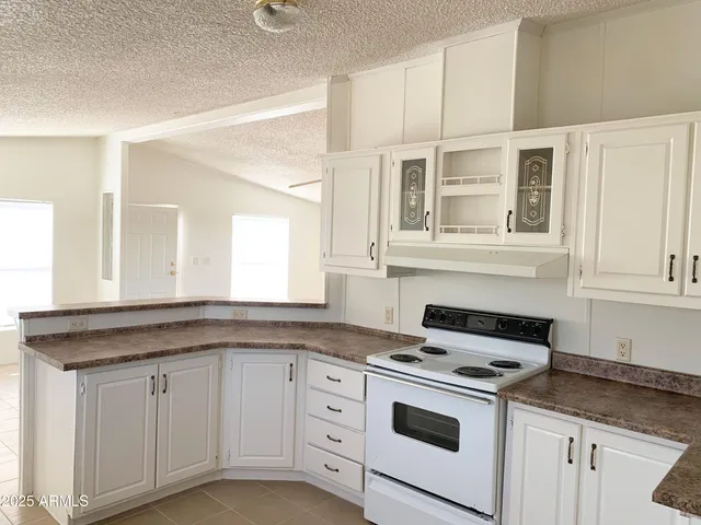 a kitchen with granite countertop white cabinets and white appliances