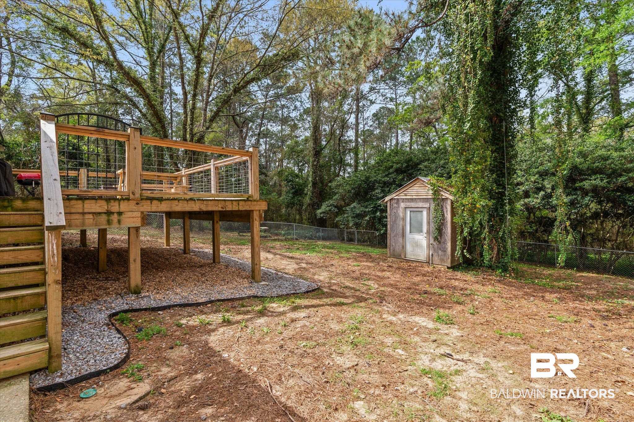 1849 Ranch House Drive Semmes, AL 36575 - Photo 20 of 23 Fenced backyard with a storage unit and a wooden deck
