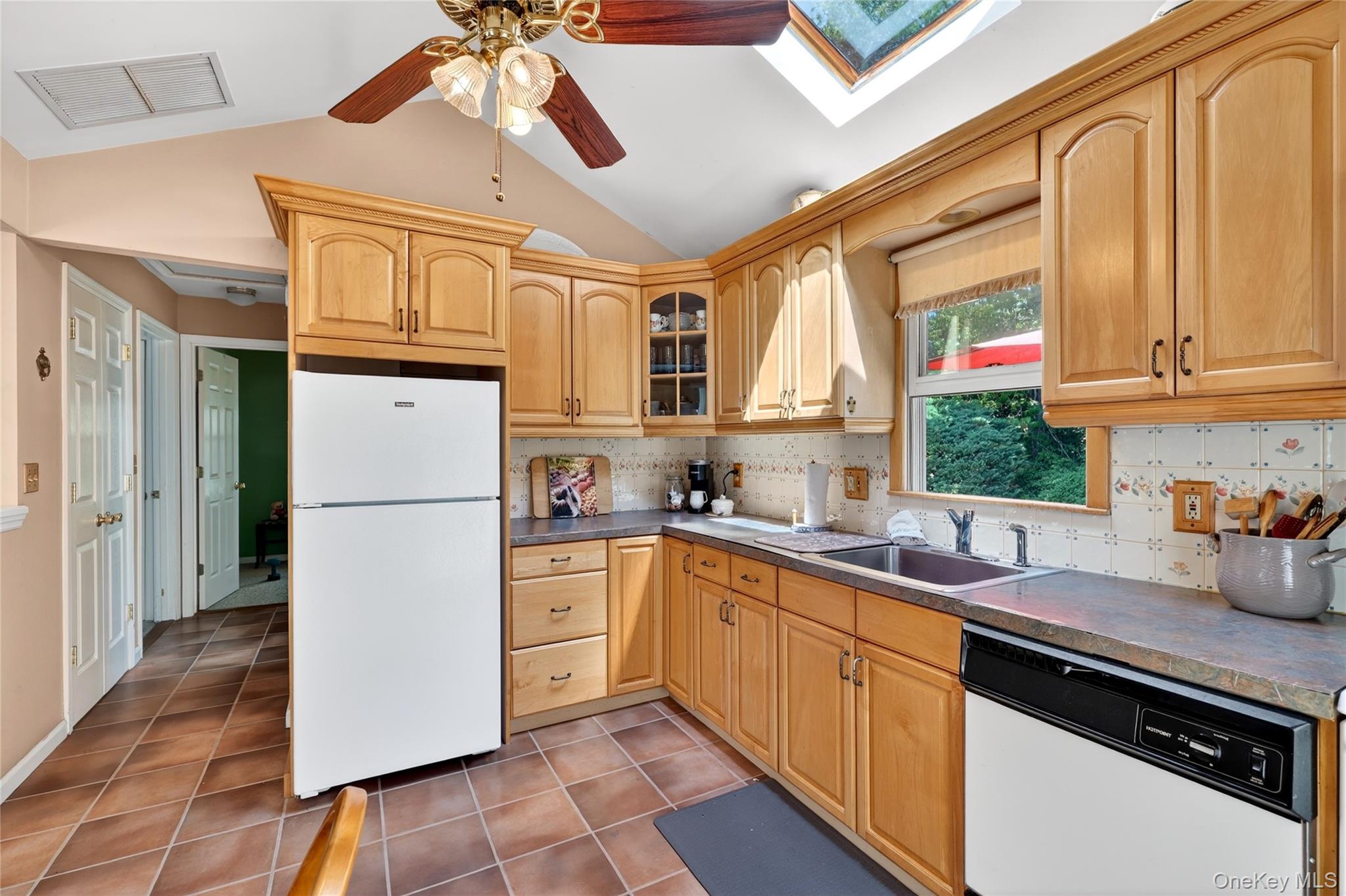 232 Cherry Road Yorktown Heights, NY 10598 - Photo 9 of 21 a kitchen with a sink a refrigerator a window and cabinets