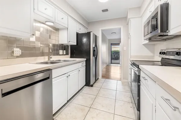 a kitchen with stainless steel appliances granite countertop a refrigerator and a stove