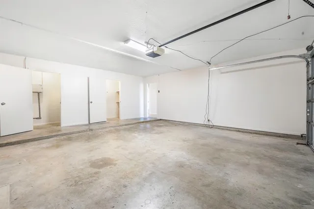 an empty room with a ceiling fan and window