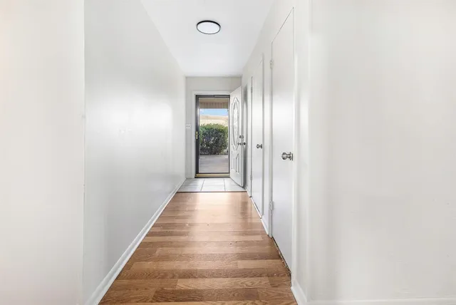 a view of a hallway with wooden floor