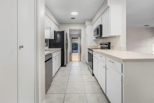 a kitchen with stainless steel appliances a refrigerator sink and microwave