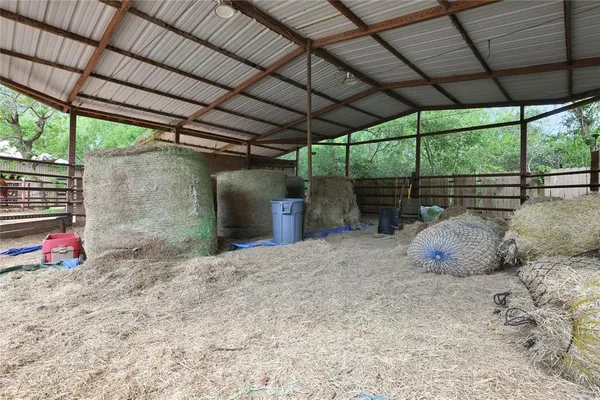 a backyard of a house with table and chairs under an umbrella