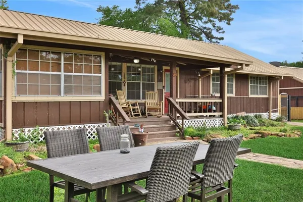 a front view of a house with a deck and furniture
