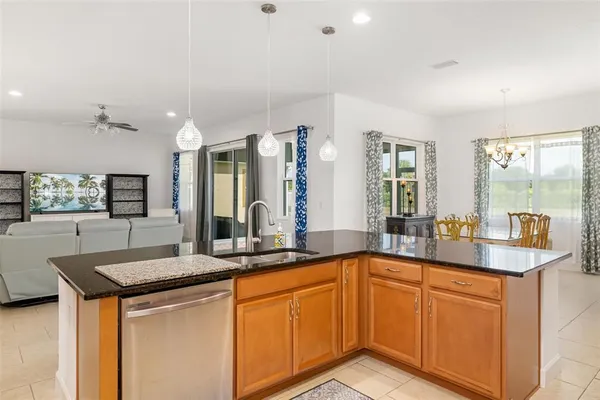 a kitchen with granite countertop a sink and white cabinets