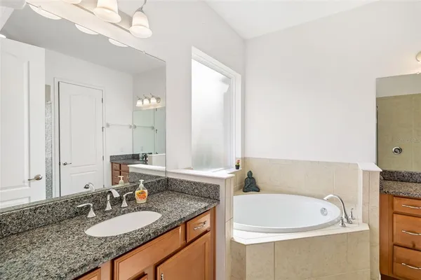 a bath room with a granite countertop sink and a mirror